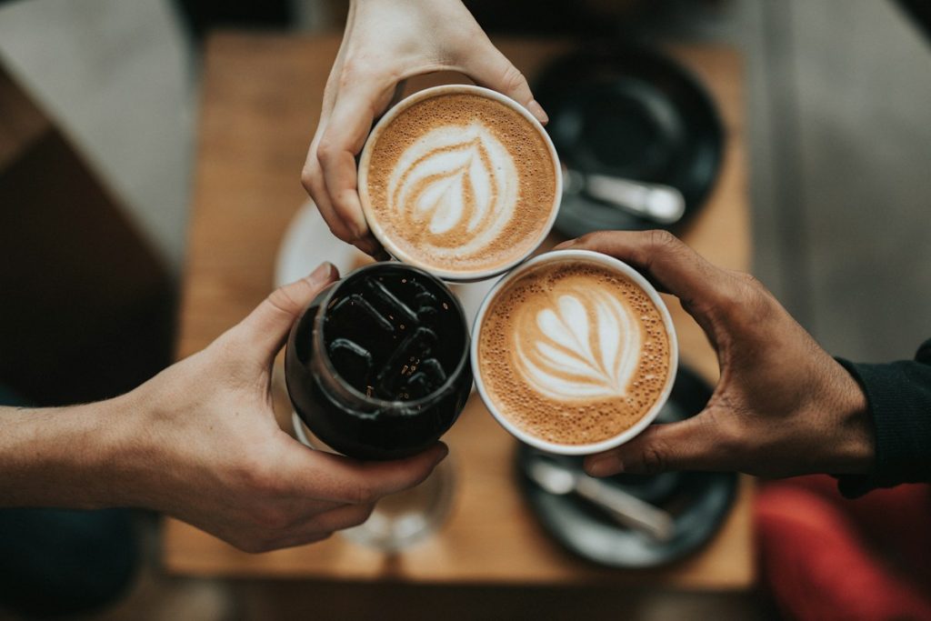 Cangkir kopi dan biji kopi di meja cafe dengan pencahayaan hangat