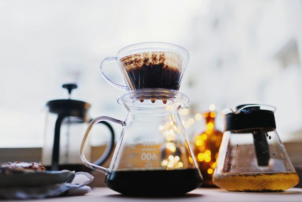 Peralatan seduh kopi dan suasana cafe dengan cahaya hangat